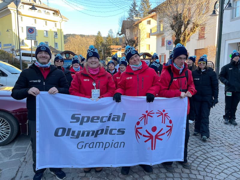 4 people holding a banner saying Special Olympics Grampian