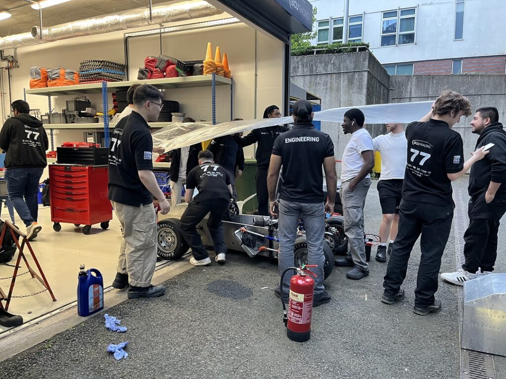 BCURT crew run checks on the car in the rain.