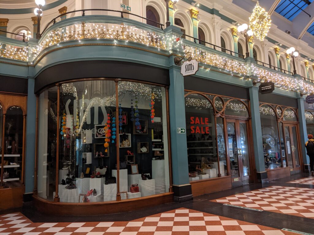 View of the shop window for Sims Footwear, located in Birmingham's Great Western Arcade.