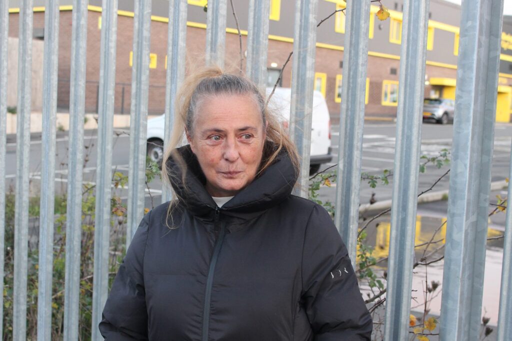 Wendy outside of the Tyseley depot fence, looking away from the camera with a slight smile but mostly serious look.
