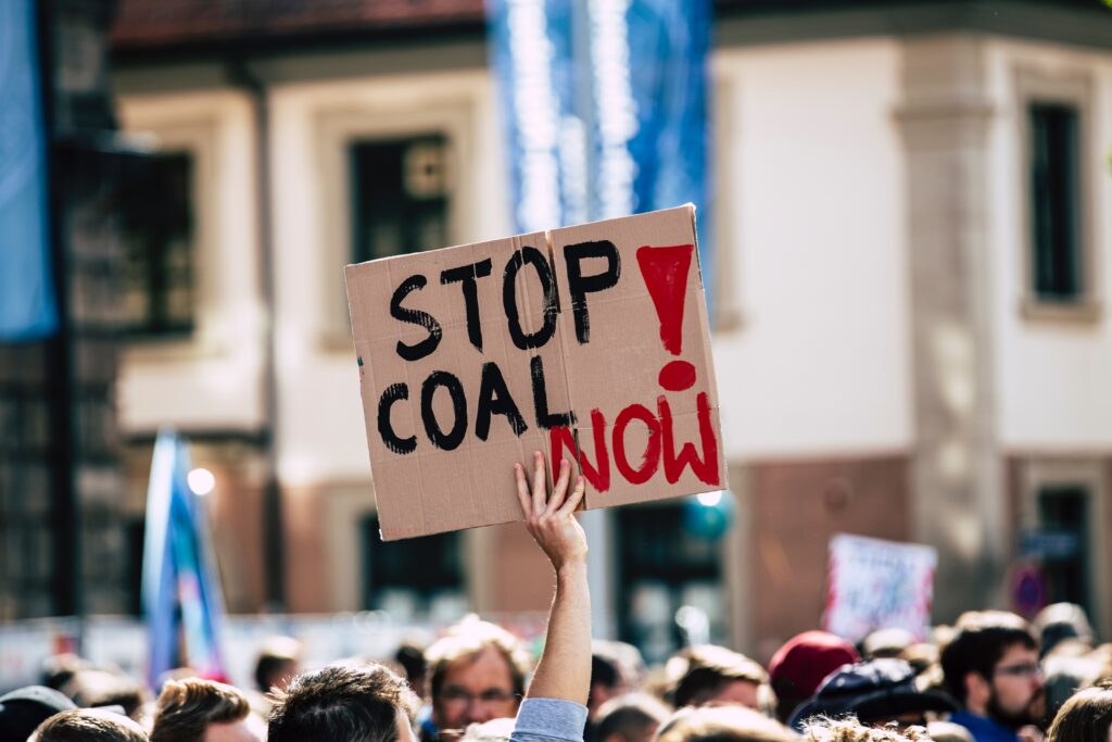 Protestors with sign saying 'Stop Coal Now'