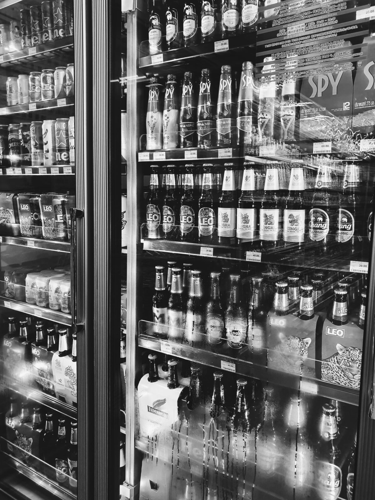 Black and white image of a fridge containing alcohol