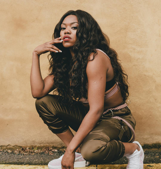Lady Leshurr kneeling down and posing for the camera