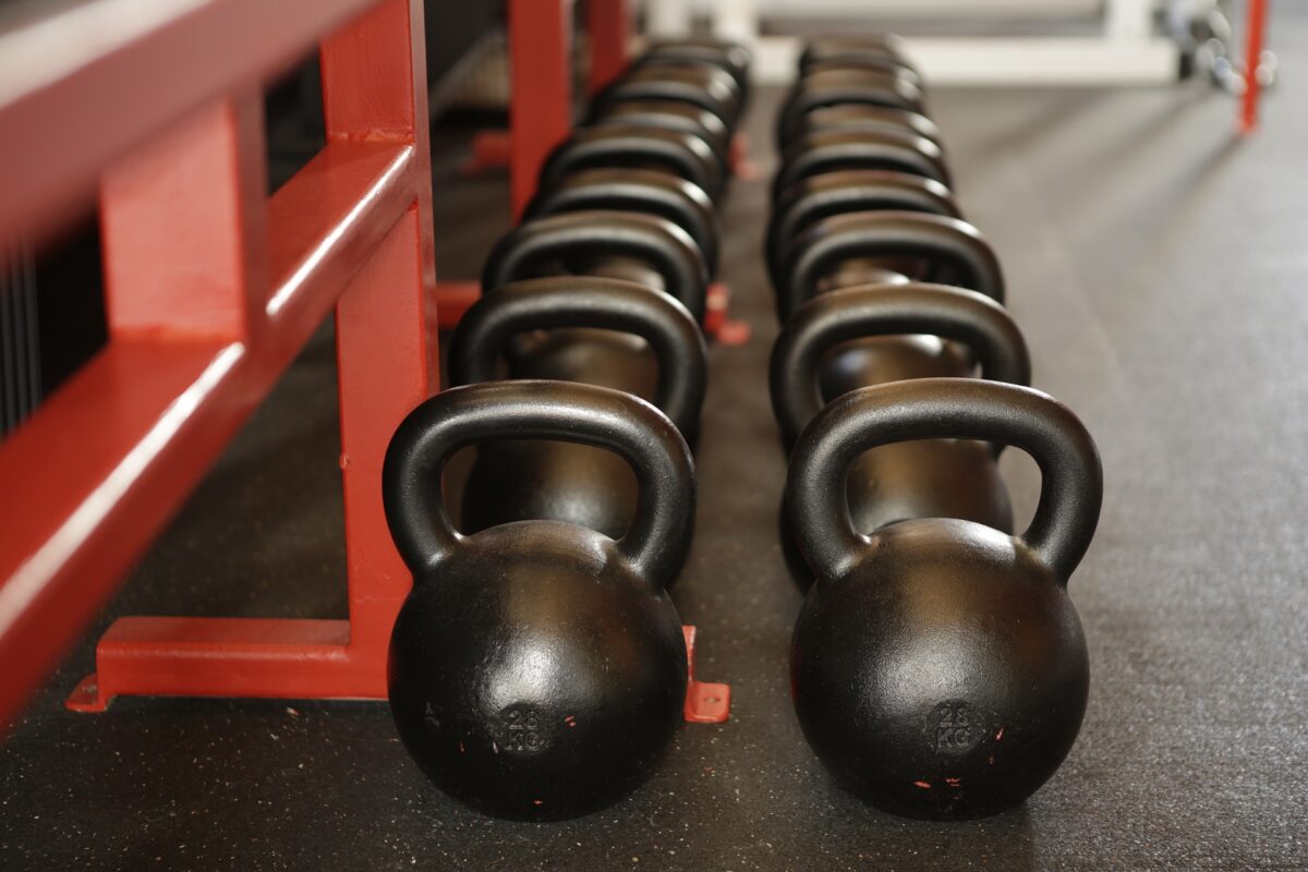 Kettle bells lined up on the floor in a fitness center