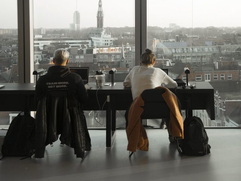 Students study with a view looking out across the city.